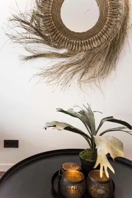 a mirror hanging on a wall above a table with a plant at Sack-Time fashion boutique hotel 6 & 7 in Zandvoort