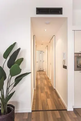 a hallway with white walls and a potted plant at Sack-Time fashion boutique hotel 6 & 7 in Zandvoort