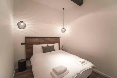 a bedroom with a white bed with two towels on it at Sack-Time fashion boutique hotel 6 & 7 in Zandvoort