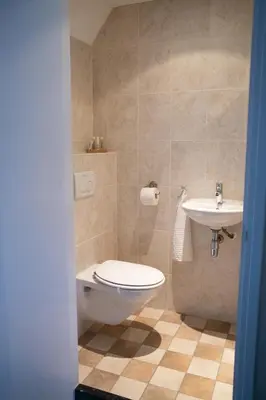 a bathroom with a toilet and a sink at Hoeve te Gast - vakantieboerderij in Groet