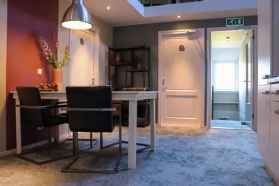 a kitchen with a table and chairs in a room at Hoeve te Gast - vakantieboerderij in Groet