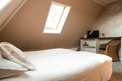a bedroom with a bed and a window at Hoeve te Gast - vakantieboerderij in Groet