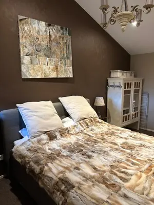 a bedroom with a large bed and a painting on the wall at Veld en Bosch in Leusden