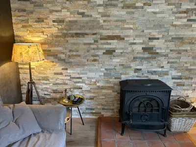 a fireplace in a living room with a brick wall at Veld en Bosch in Leusden