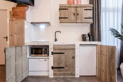 a kitchen with white appliances and wooden cabinets at Beach Studio Boom in Zandvoort