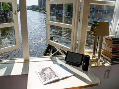 a desk with a book and a tablet next to a window at SWEETS - Van Hallbrug in Amsterdam