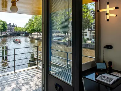 a room with a window with a view of a river at SWEETS - Hortusbrug in Amsterdam
