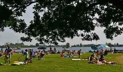 a crowd of people sitting on the grass at a park at Slapen bij de Buurvrouw in Castricum