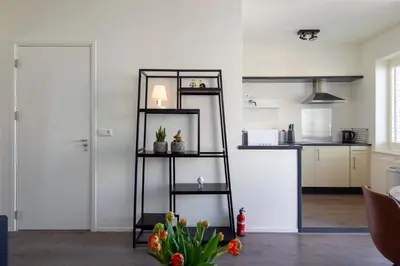 a black shelf in a room with a kitchen at Seapoint - Sea view in Zandvoort