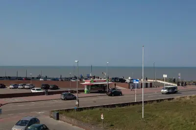 a parking lot with cars and a gas station at Seapoint - Sea view in Zandvoort