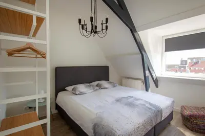 a bedroom with a bed and a chandelier at Seapoint - Sea view in Zandvoort