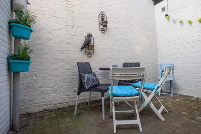 a table and chairs on a patio with plants at Oosterhouse in Zandvoort