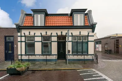 a white and black house with an orange roof at Oosterhouse in Zandvoort