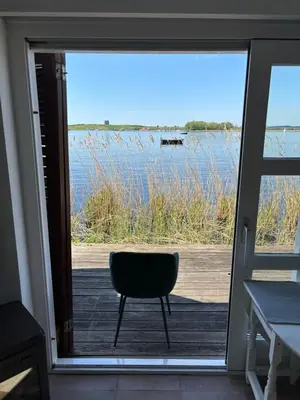 a chair sitting in front of a sliding glass door at Vakantiehuis aan De Mooie Nel in Spaarndam