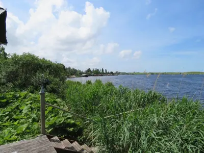 a view of a river with grass and water at Vakantiehuis aan De Mooie Nel in Spaarndam