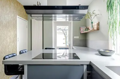 a kitchen with a glass counter top and chairs at Family Home Hendriks in Zandvoort