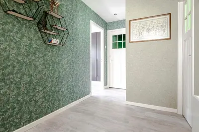 a hallway with green wall paper and a white door at Family Home Hendriks in Zandvoort