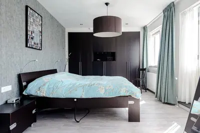 a bedroom with a bed with a blue comforter at Family Home Hendriks in Zandvoort