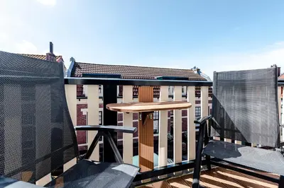 a balcony with a wooden table and two chairs at Family Home Hendriks in Zandvoort
