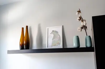 a shelf with vases and a picture of a horse on it at Family Home Hendriks in Zandvoort