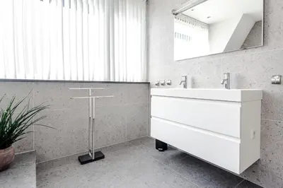 a bathroom with a white sink and a mirror at Family Home Hendriks in Zandvoort