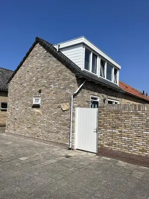 a large brick building with a white door at Sonnblick in Egmond aan Zee