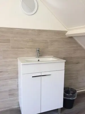 a bathroom with a white sink and a mirror at Sonnblick in Egmond aan Zee