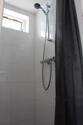 a shower with a black shower curtain in a bathroom at Sonnblick in Egmond aan Zee