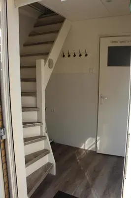 a room with stairs and a hallway with a door at Sonnblick in Egmond aan Zee