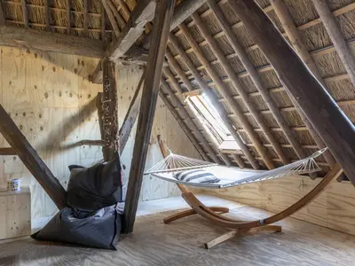 two hammocks in a room in a attic at Luxuriously restored farmhouse with trendy interior close to sea and forest in Groet