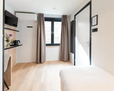 a bedroom with a bed and a window at Hotel van Gelder in Amsterdam