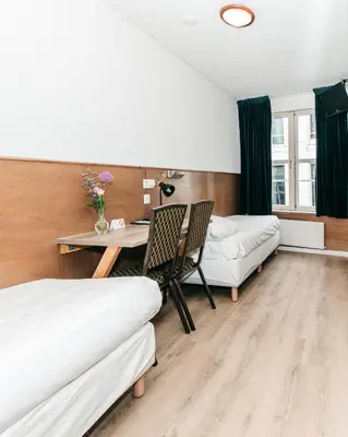 a bedroom with two beds and a table and chairs at Hotel van Gelder in Amsterdam