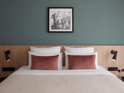 a bedroom with a large bed with red pillows at Numa Amsterdam Docklands in Amsterdam