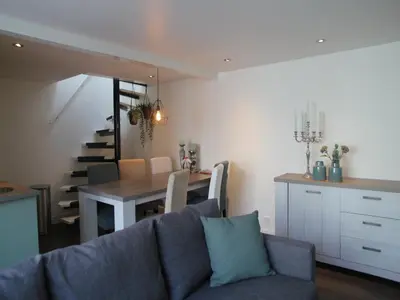 a kitchen and dining room with a couch and a table at Holiday Home in Egmond by the Beach in Egmond aan Zee