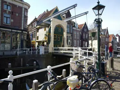 a group of bikes parked next to a canal at Holiday Home in Egmond by the Beach in Egmond aan Zee