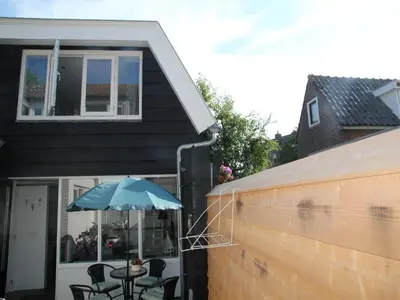 a patio with a table and an umbrella at Holiday Home in Egmond by the Beach in Egmond aan Zee
