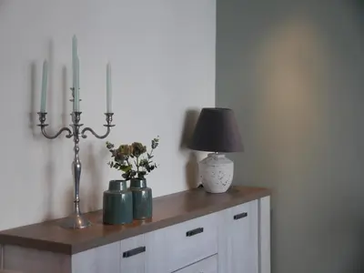 a table with a lamp and two vases with flowers on it at Holiday Home in Egmond by the Beach in Egmond aan Zee