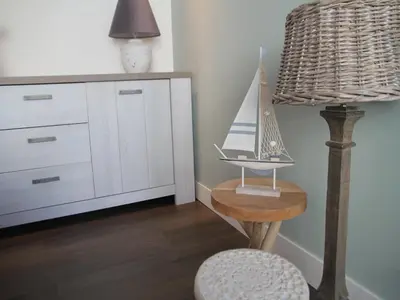 a room with a table and a lamp and a chair at Holiday Home in Egmond by the Beach in Egmond aan Zee
