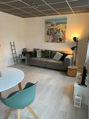 a living room with a couch and a table at De Nollen in Egmond aan den Hoef
