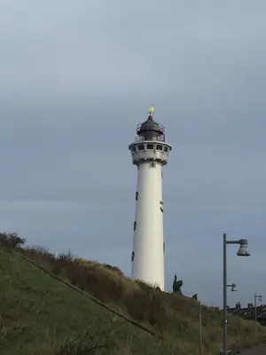 a white lighthouse sitting on top of a hill at De Nollen in Egmond aan den Hoef