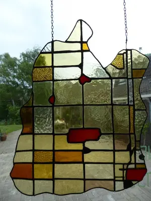 a stained glass window of a dog on a swing at Beemster Oase in De Beemster
