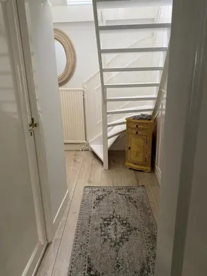 a hallway with a rug on the floor and a staircase at Casa Blanca Old City - Alkmaar in Alkmaar