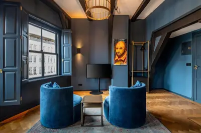 a living room with blue chairs and a lamp at CTY Books in Leiden