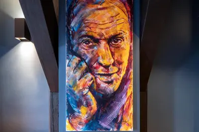 a painting of a mans face on a wall at CTY Books in Leiden