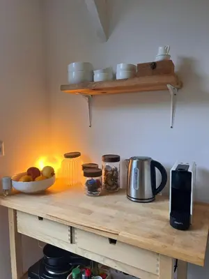 a wooden counter with a bowl of fruit on it at Cozy tiny house close to Schiphol Ams Airport in Rijsenhout