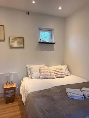 a bedroom with a large white bed with a window at Cozy tiny house close to Schiphol Ams Airport in Rijsenhout