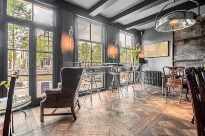 a room with a table and chairs and windows at Boutique Hotel The Craftsmen in Amsterdam