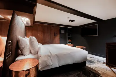 a bedroom with a large white bed and a table at Boutique Hotel The Craftsmen in Amsterdam