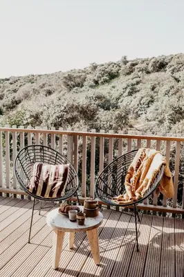 two chairs and a table on a deck with a view at Strandhotel Zoomers in Castricum
