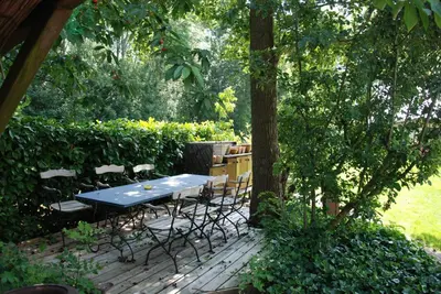 a table and chairs on a patio under a tree at Villa Pantano in Berkhout